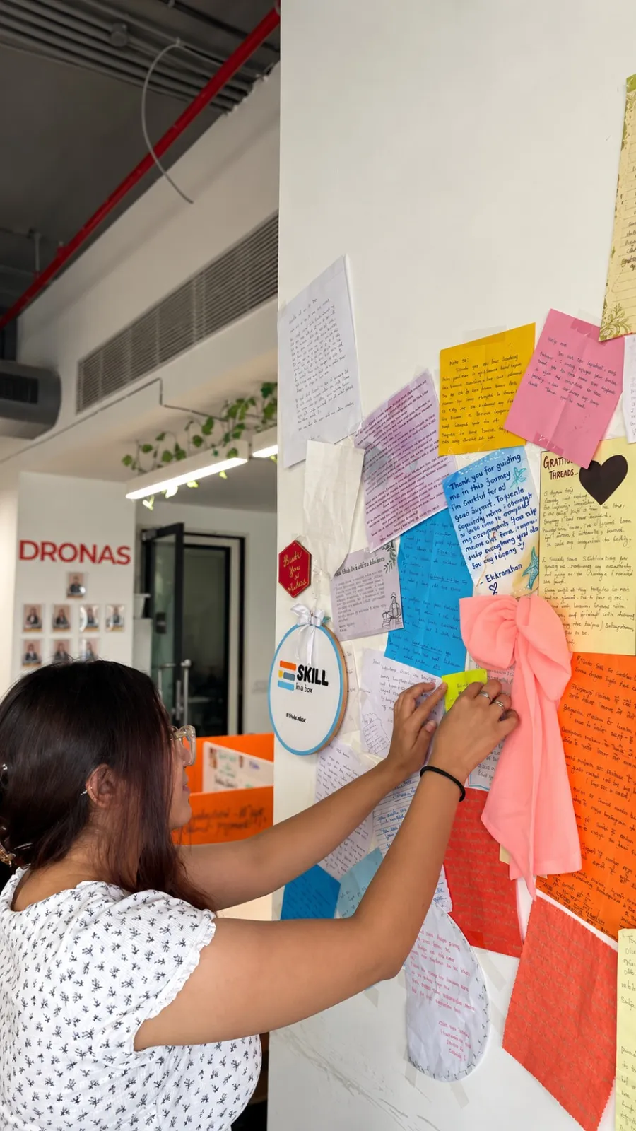A founder pinning her note to the gratitude wall